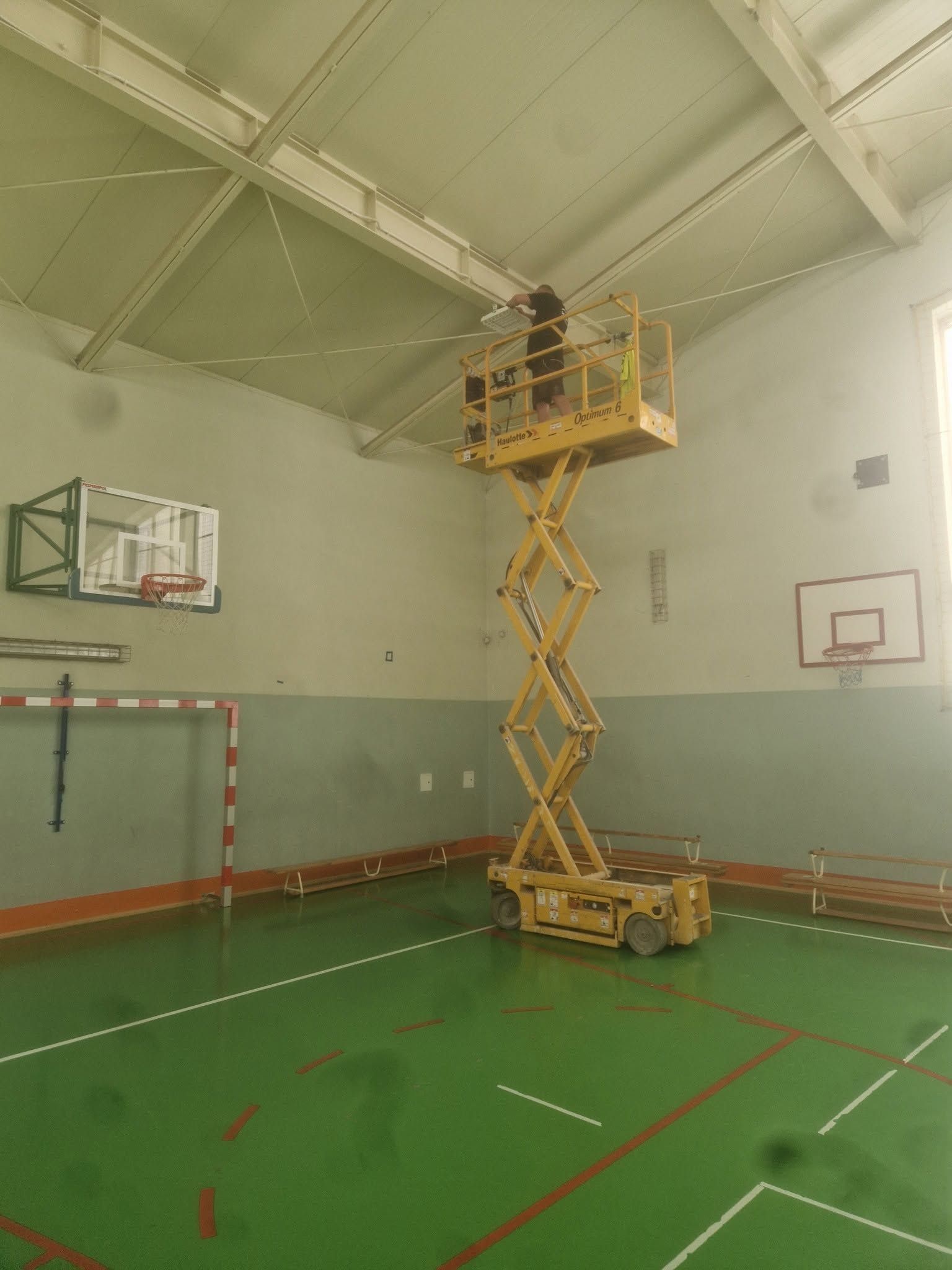 Podnośnik nożycowy przy suficie hali sportowej